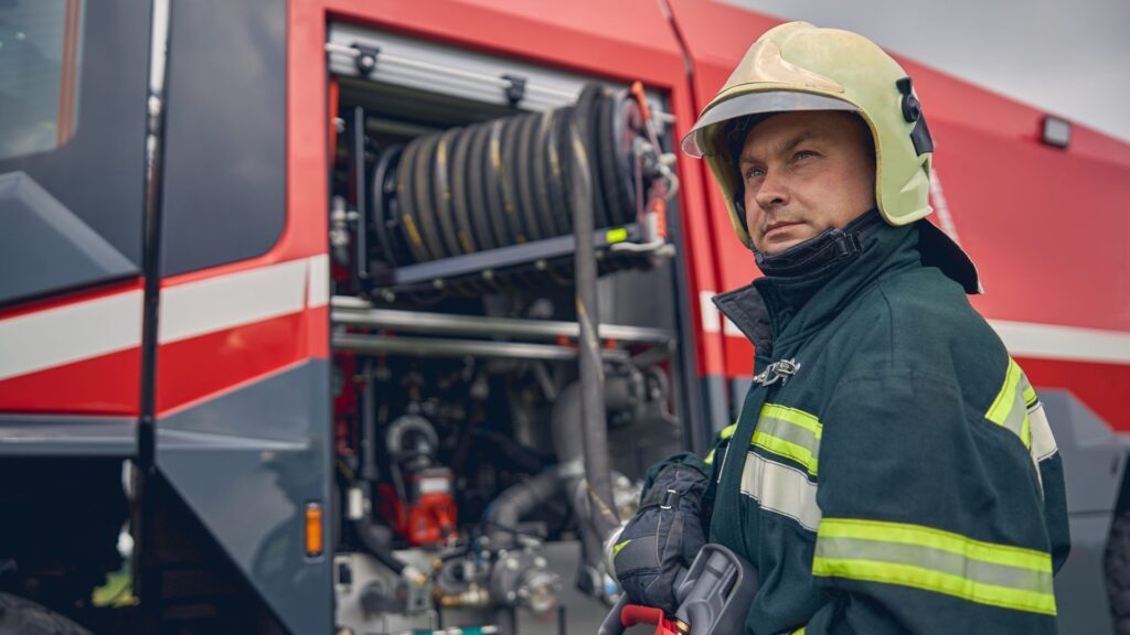 firefighter-is-standing-near-the-fire-truck-e1697420582678.jpg